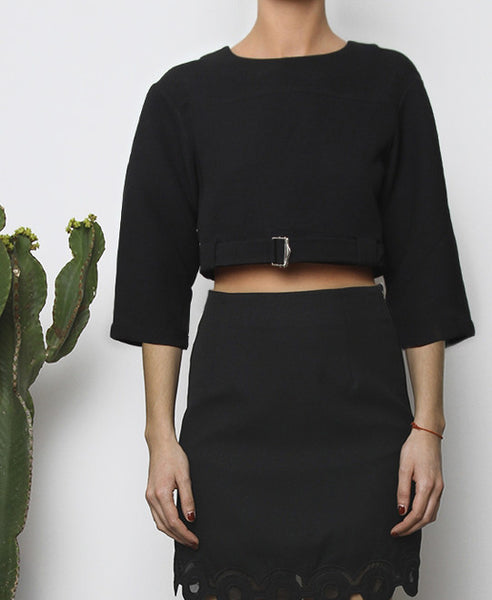 Bella London Black cropped top with boxy fit, front silver buckle fastening and ¾ sleeves. Close up front photo.