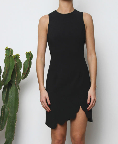 Bella London Augi Little Black Dress with asymmetric scalloped hem and a slight leg slit. Close up front photo.