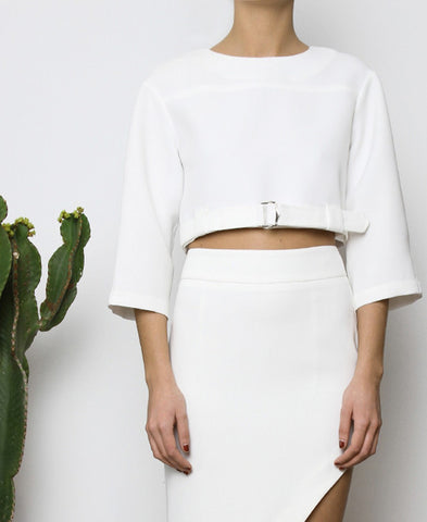 Bella London White cropped top with boxy fit, front silver buckle fastening and ¾ sleeves. Close up front photo.