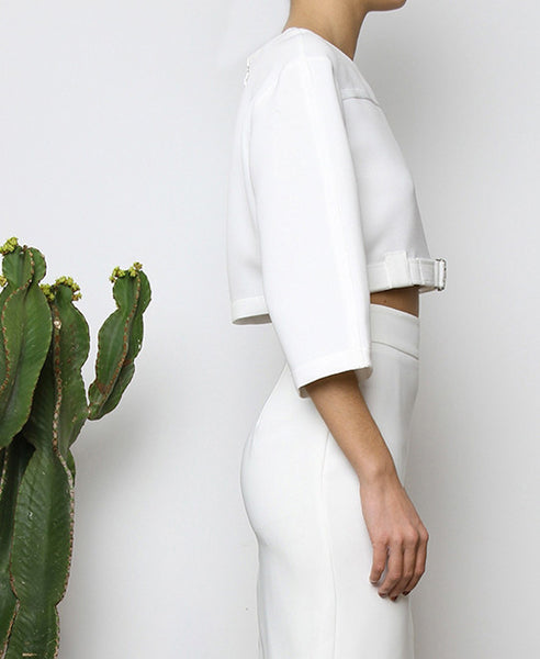 Bella London White cropped top with boxy fit, front silver buckle fastening and ¾ sleeves. Close up side photo.